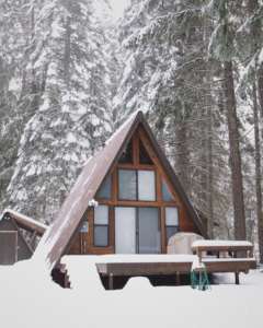 A-frame cabin in the woods covered in snow